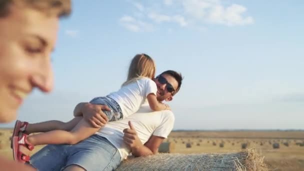 Genitori felici che giocano con la loro bella figlia sul pagliaio e hanno gioia — Video Stock