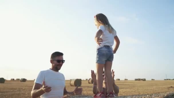 Gelukkige ouders spelen met kleine dochter, springen in de handen — Stockvideo