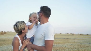 Mutlu bir aile birlikte tarlada eğleniyor.