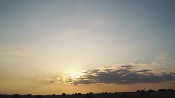 Kleurrijke zonsondergang achtergrond op een veld met hooibergen — Stockvideo