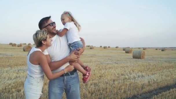 Hermoso retrato de la familia alegre juntos jugando a cámara en un campo — Vídeos de Stock