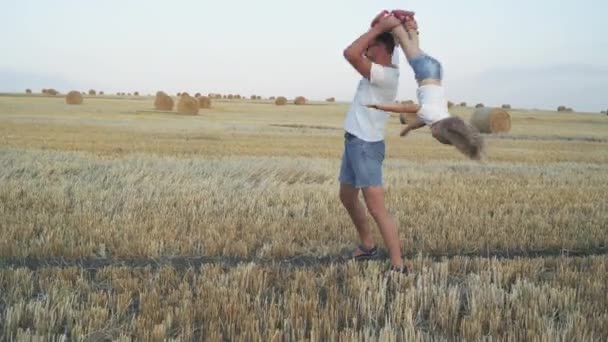 Glückliche Familie spielt mit ihrer Tochter, Vater verdreht ihr die Beine — Stockvideo