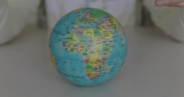 Close covering the globe with medical mask and grasp it by hands at camera