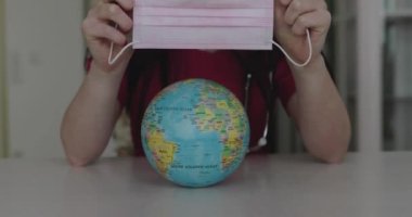 Female hands tightening the globe with a medical mask at camera