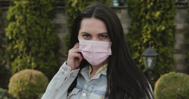 Cured, girl in garden undresses medical mask, corrects hair and smiles at camera — Wideo stockowe