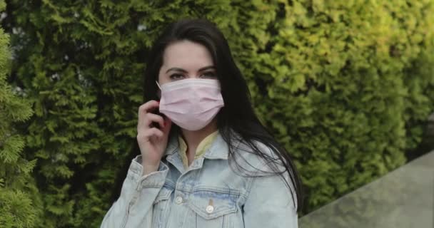 Cured, happy girl in coniferous garden undresses medical mask, throws out it — Stock videók