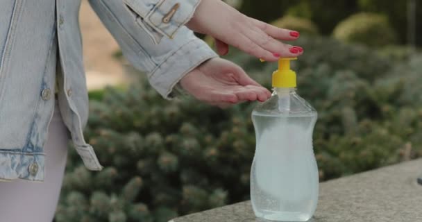 Close view of female hands disinfectants hand with sanitizer outdoors — Vídeos de Stock