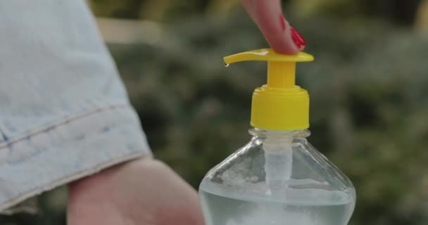 Close view of female hands pushes sanitizer and disinfectants hand outdoors — Vídeos de Stock