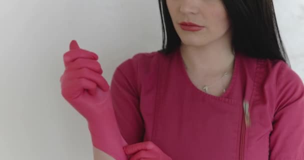 View of pretty nurse wearing pink gloves on background — Stockvideo