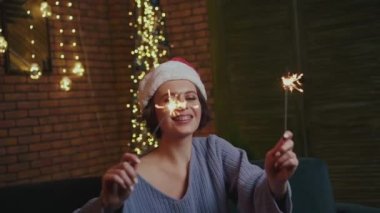 Samimi, mutlu bir kız odada alevli maytaplarla oynuyor.