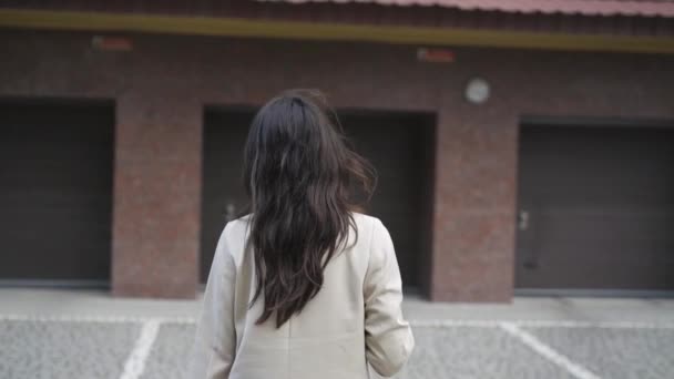 一个快乐的黑发女子走着，转身对着相机笑着的后视镜 — 图库视频影像