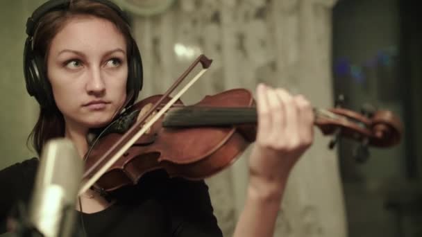 Der Musiker mit Kopfhörer spielt Geige am Mikrofon während einer Probe — Stockvideo