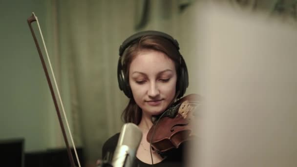 Jeune violoniste heureux avec écouteurs jouant du violon pendant une répétition — Video