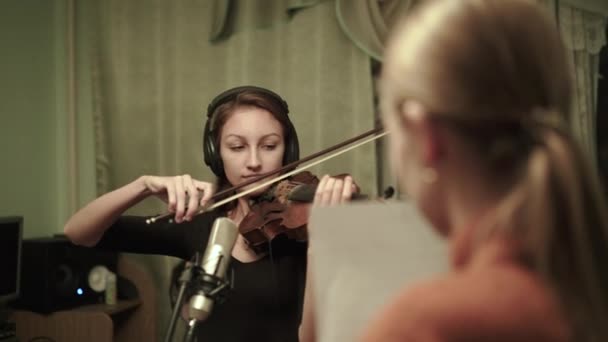 Jeune violoniste avec écouteurs jouant du violon en studio — Video