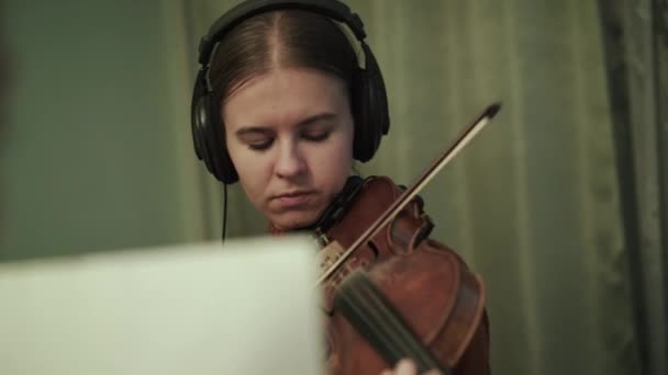Umělkyně se sluchátky nacvičující melodii s houslemi pod vedením mentora — Stock video