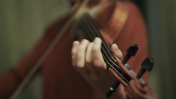 Vista de cerca de tocar rápido en el violín por la joven durante el ensayo en una sala — Vídeos de Stock