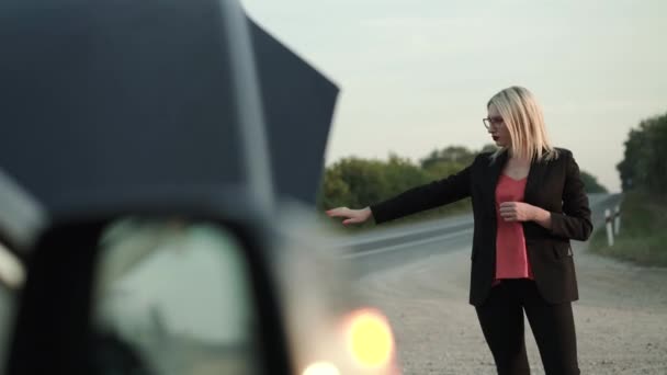 Vue sur une voiture clignotant phare d'une femme s'arrêtant en auto-stop — Video