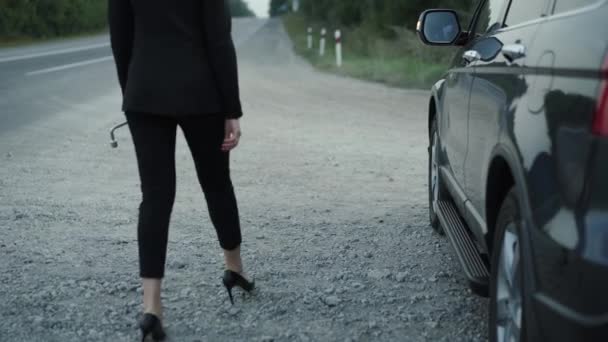 Elegante dama desmonta la rueda en coche roto con nervioso en carretera suburbana — Vídeos de Stock