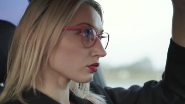 Гламурная леди в очках наносит красную помаду на зеркало в машине — стоковое видео