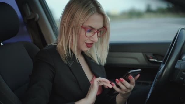 Glad blond ringer ett nummer och talar på smartphone i bilen — Stockvideo