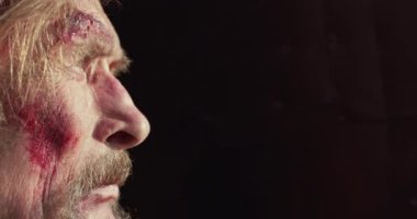 Siyah arka planda yaralı yaşlı Kazağın profil portresi