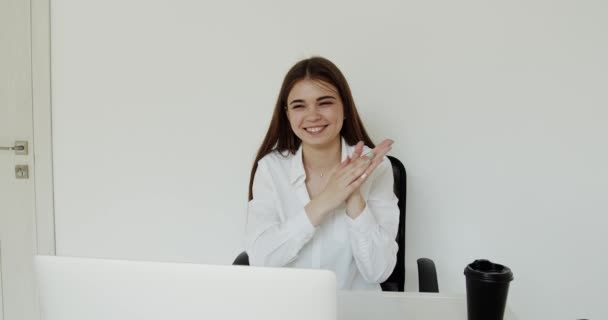 Glad ung flicka jublar när videochattar på laptop på arbetsplatsen på kontoret — Stockvideo