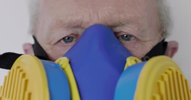 Makro widok seniora nosił w uniwersalnym respiratorze patrząc w aparat — Wideo stockowe
