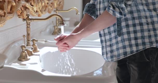 Hombre persona se enciende el grifo que fluye, jabones manos y los lava bajo el agua — Vídeo de stock