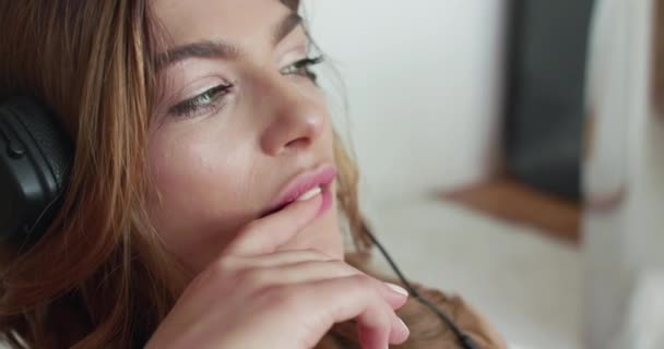 Wanita dengan headphone, terlihat menggoda di kamera dan membelai bibir dengan jari — Stok Video