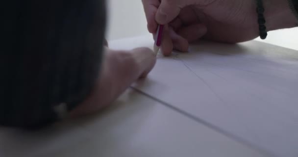 Close view van mannelijke ontwerpers hand tekent een schets van de jurk op het bureau — Stockvideo