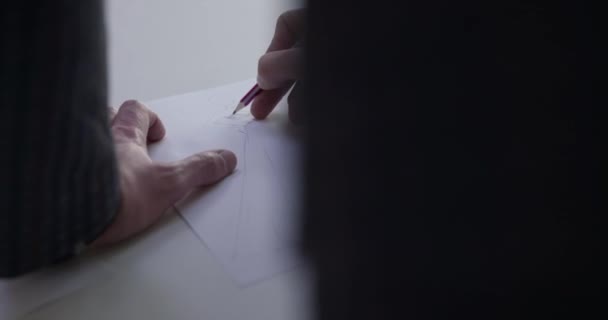 Προβολή των ανδρών σχεδιαστών χέρι σχεδιάζει ένα σκίτσο του φορέματος στο στούντιο — Αρχείο Βίντεο