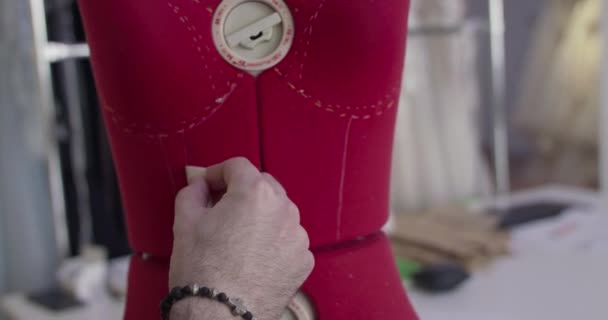 Close male designers hand draws mannequin with a dotted line in dresses atelier — Stock Video