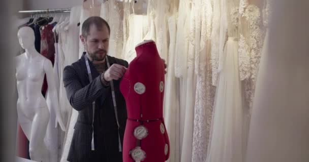 Perancang laki-laki melakukan pengukuran terhadap boneka penjahit wanita di atelier — Stok Video