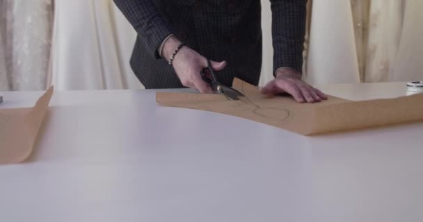 Ράφτες χέρια κοπή μια καμπύλη ιστού σε μια επιφάνεια εργασίας στο ατελιέ φόρεμα — Αρχείο Βίντεο