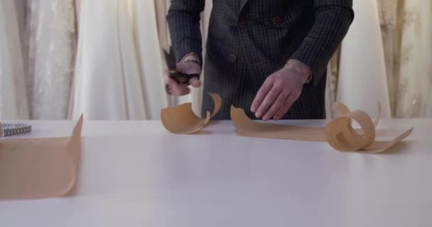 Módní návrháři ruce řezání tkáňové křivky na ploše v šaty atelier — Stock video