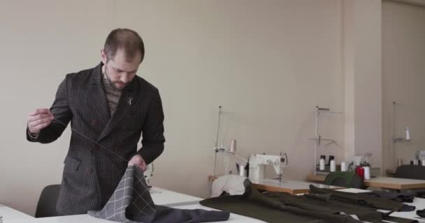 Le tailleur couture une courbe de tissu sur le bureau dans l'atelier — Video