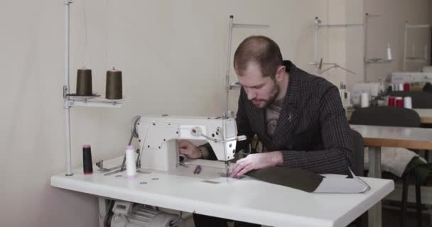 Il sarto fa un punto su un tessuto con una macchina da cucire in uno studio — Video Stock