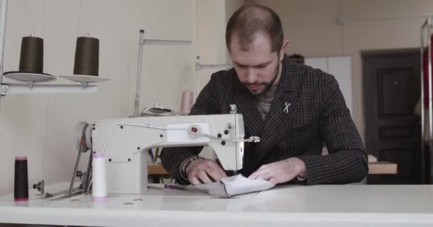O alfaiate costura roupas com máquina de costura em um estúdio — Vídeo de Stock