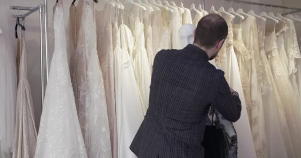 The tailor trying an evening dress on a mannequin in studio — Stock Video