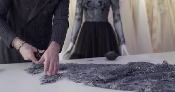 Красивый портной резки ткани во время разработки платья в ателье — стоковое видео