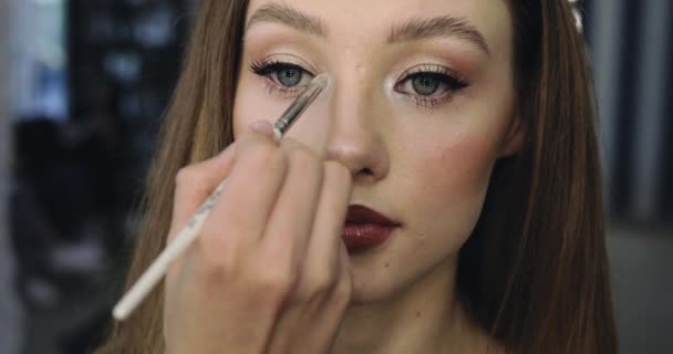 Pige med perfekt nøgen make-up. Nærbillede af make-up proces for smukke unge kvindelige model – Stock-video
