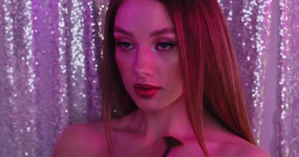 Glamour meisje met perfecte make-up in roze licht. Close-up van mooi jong model op een briljante achtergrond. Het meisje beweegt een borstel door haar sleutelbeen . — Stockvideo