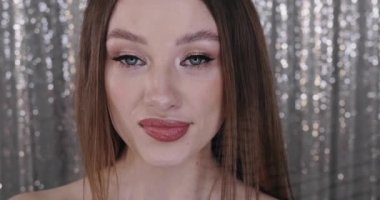 Mükemmel makyajlı, genç ve güzel bir bayan modelin yakın plan fotoğrafı. Kırmızı rujla çizimler yapıyor.
