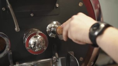 Kahve çekirdeklerini hazırlama işlemini erkek eller kontrol ediyor