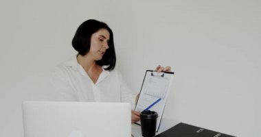 Ders veren biri dizüstü bilgisayarla sohbet ediyor, ofiste kahve içiyor.