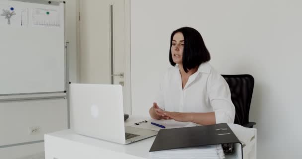 Lehrerin plaudert während des Fernlernens im Büro auf einem Laptop — Stockvideo