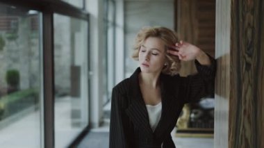 Takım elbiseli güzel kız ve saç stili lüks bir evde poz veriyor.