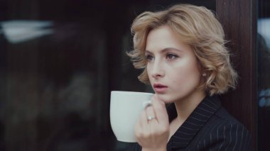 Güzel bir bayanın portresi evde bir fincan çay içer ve düşünür. 4K