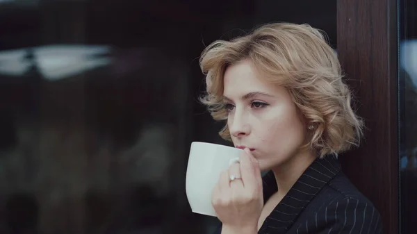 Portrait of beautiful lady thinks and drinks a cup of tea at house. 4K Stock Picture