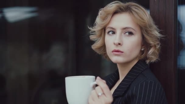 Portret pięknej damy myśli i pije filiżankę herbaty w domu. 4K — Wideo stockowe